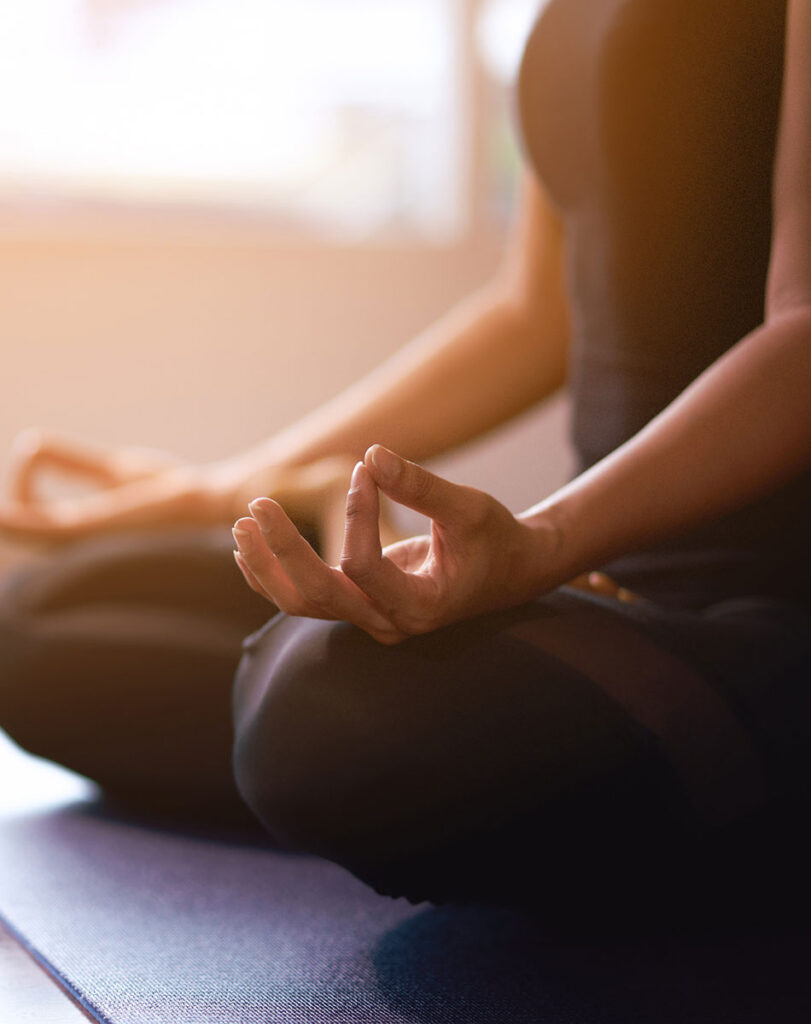 Women in meditation while practicing yoga in a training room. Happy, calm and relaxing.