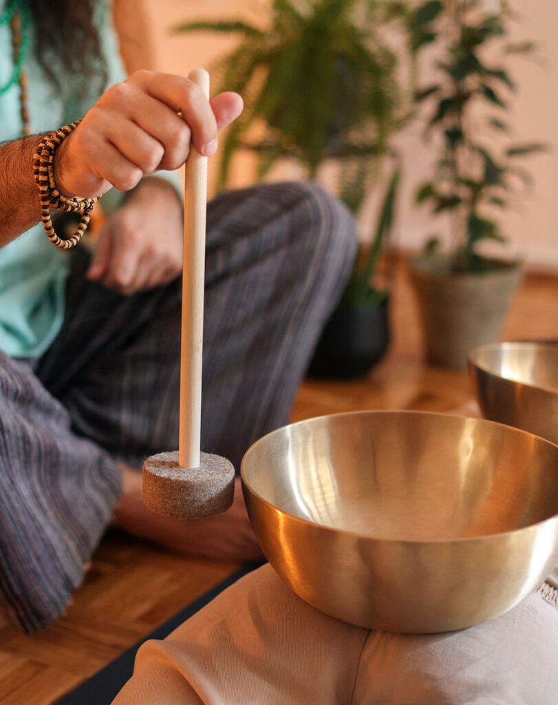 A man sitting on the floor with a bowl of water, engaged in a peaceful moment of reflection and tranquility.