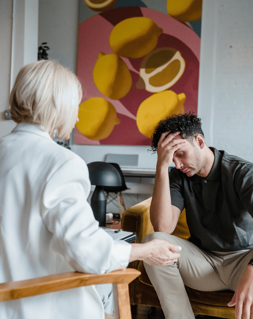 Older woman and young man talking in front of colorful wall art