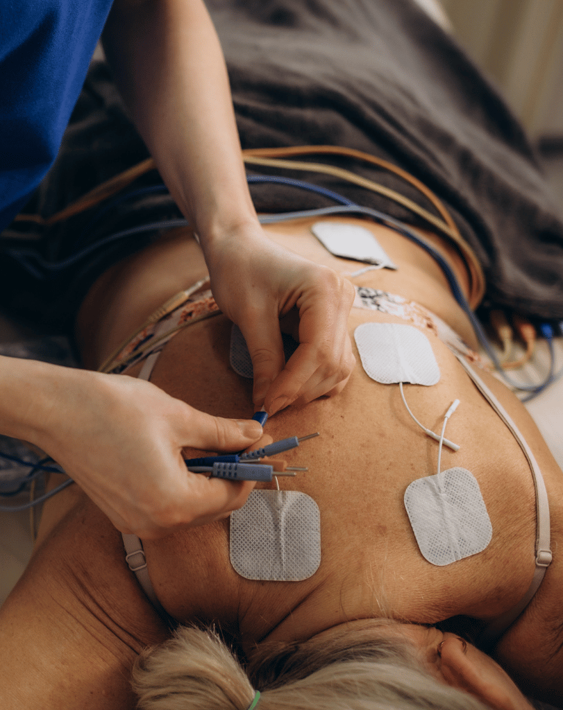 Electrode pads being placed on a person’s back
